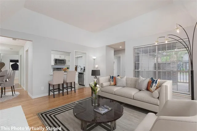 a living room with furniture and a table with wooden floor