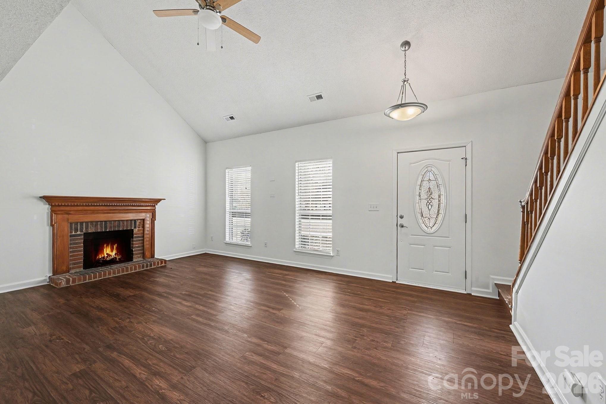 3402 Mayhurst Drive Indian Trail, NC 28079 - Photo 5 of 23 an empty room with wooden floor fireplace and windows