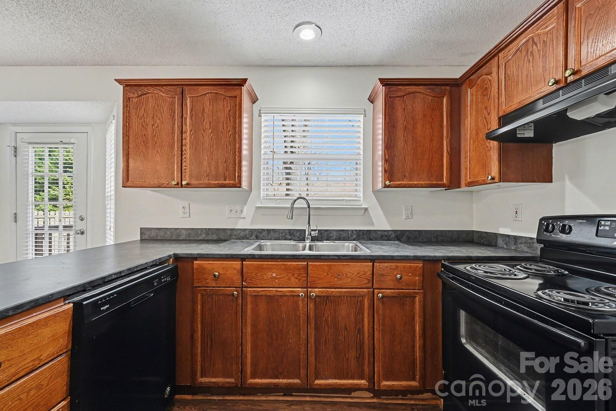 3402 Mayhurst Drive Indian Trail, NC 28079 - Photo 8 of 23 a kitchen with granite countertop a stove top oven a sink dishwasher and cabinets with wooden floor