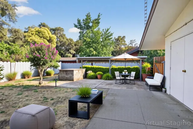 a view of a patio with table and chairs under an umbrella
