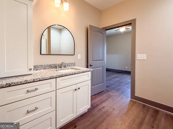 a bathroom with a granite countertop double vanity sink and mirror