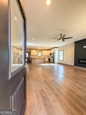 a view of a living room a dining room with wooden floor and a large window