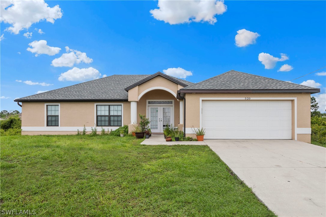 520 Raintree Street East Lehigh Acres, FL 33974 - Photo 1 of 18 a front view of a house with garden