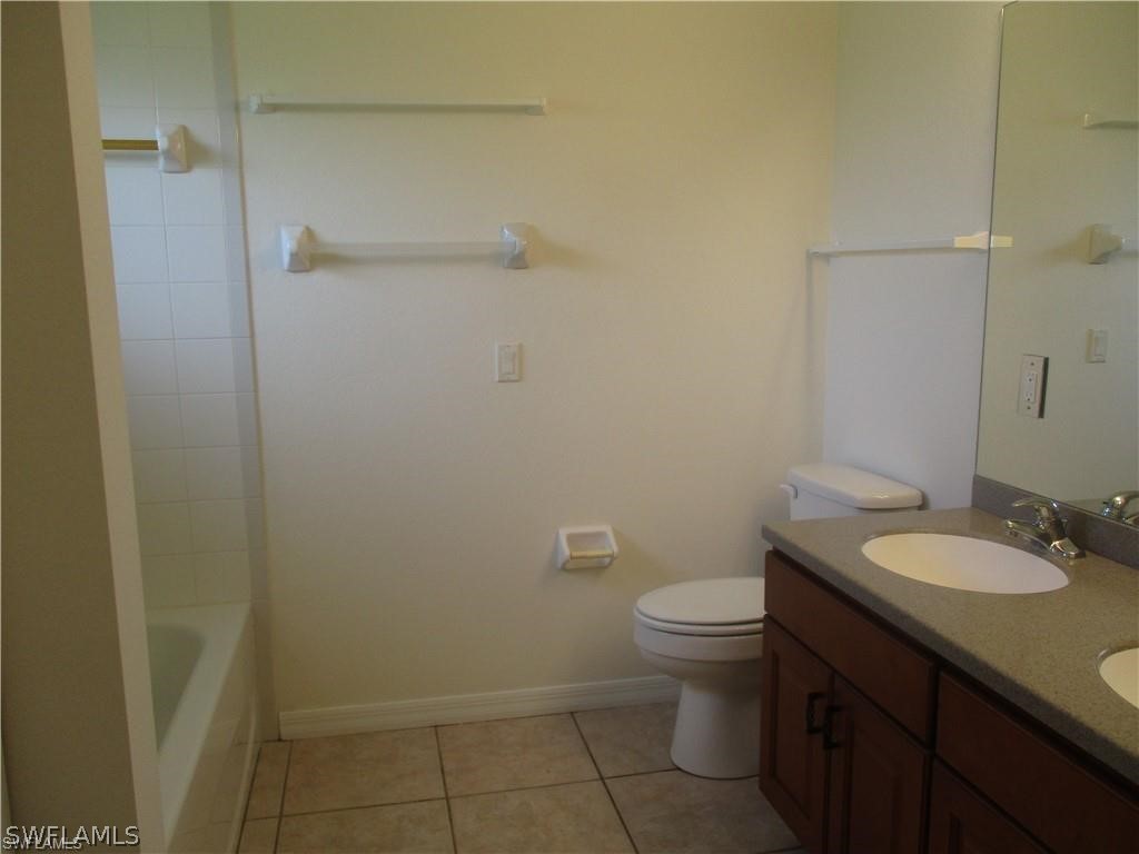 520 Raintree Street East Lehigh Acres, FL 33974 - Photo 17 of 18 a bathroom with a granite countertop toilet and a sink