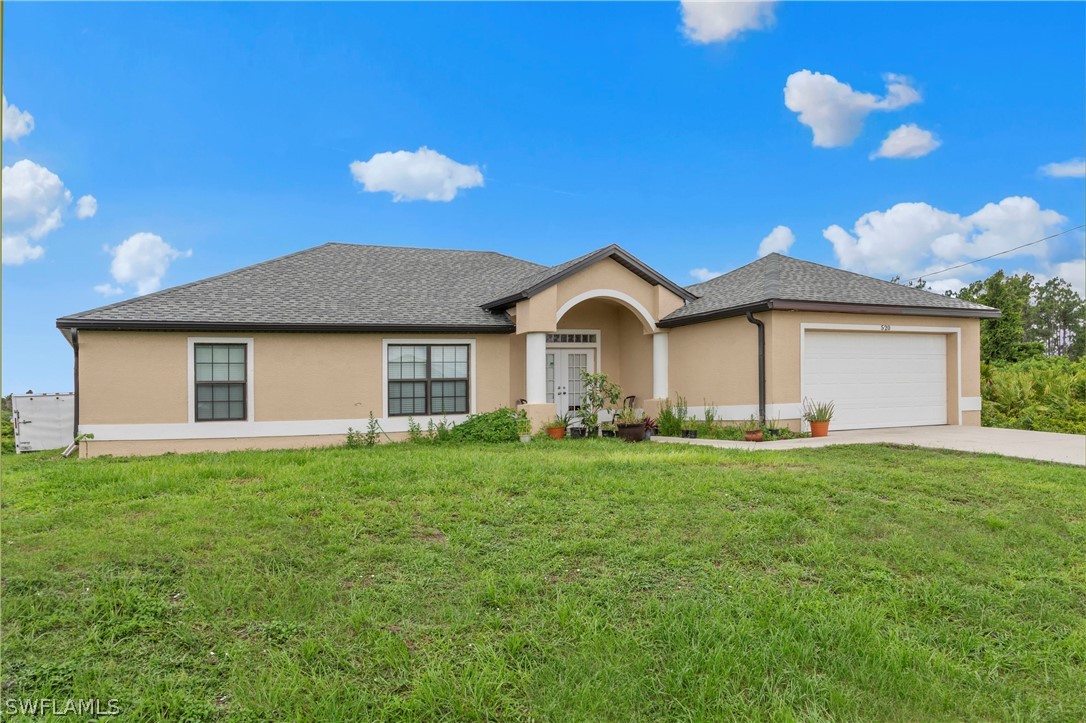 520 Raintree Street East Lehigh Acres, FL 33974 - Photo 3 of 18 a front view of a house with garden