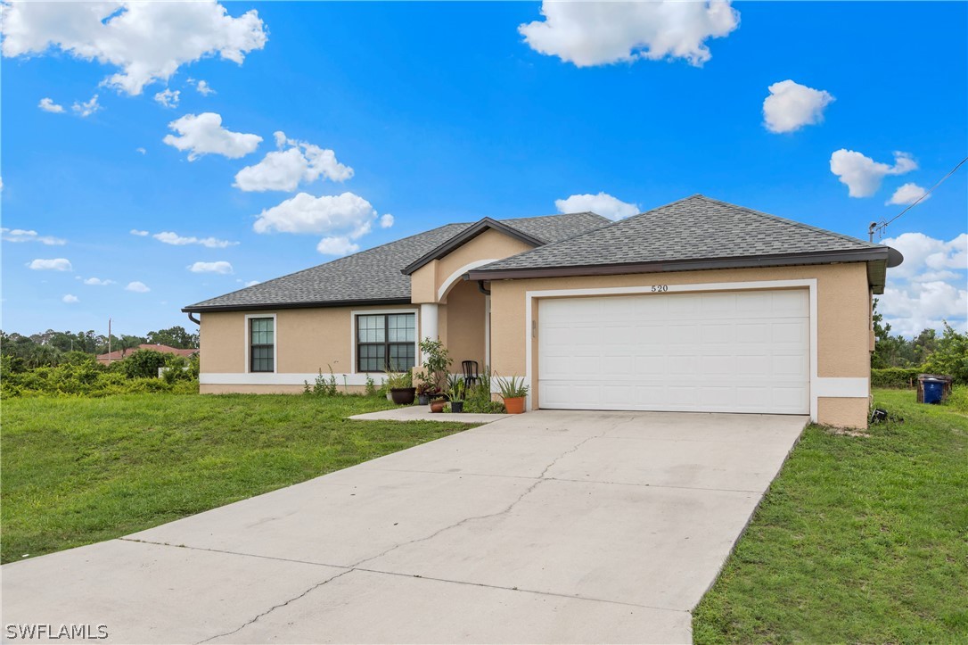520 Raintree Street East Lehigh Acres, FL 33974 - Photo 4 of 18 a view of a house with a yard