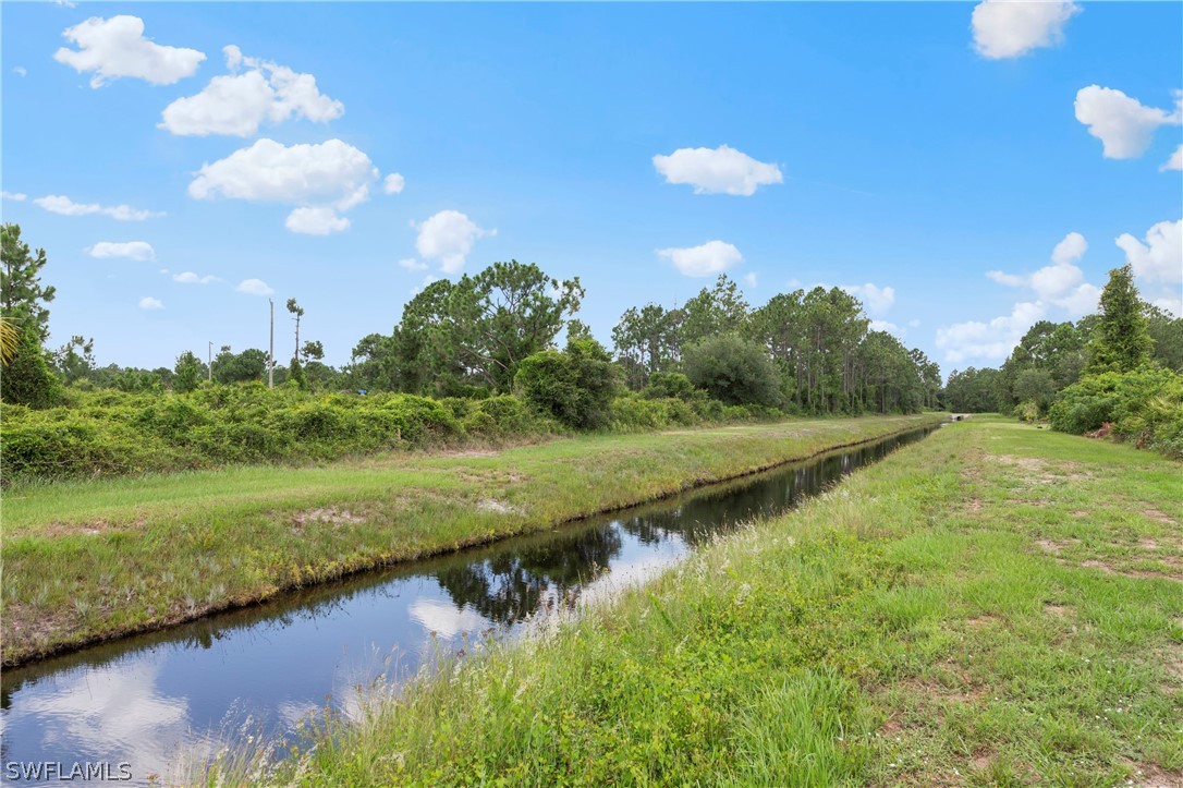 520 Raintree Street East Lehigh Acres, FL 33974 - Photo 6 of 18 a view of a lake with houses in the back