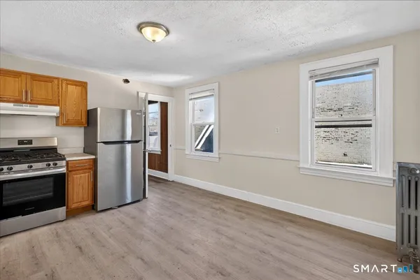 a kitchen with a refrigerator and a stove top oven
