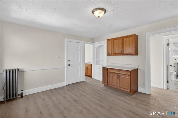 an empty room with a fireplace and wooden floor