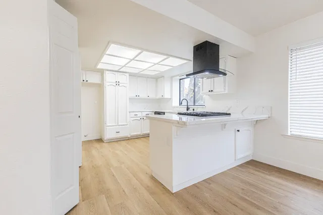 a kitchen with a refrigerator and a stove top oven