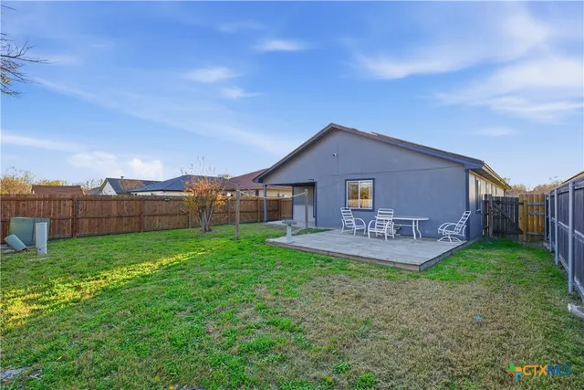 a view of a house with a yard and sitting area