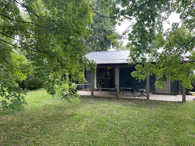 a view of a chair and table in backyard of the house
