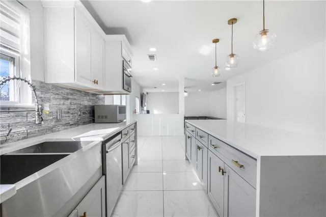 a kitchen with stainless steel appliances a sink stove and cabinets