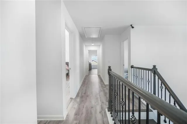 a view of a hallway with wooden floor and staircase