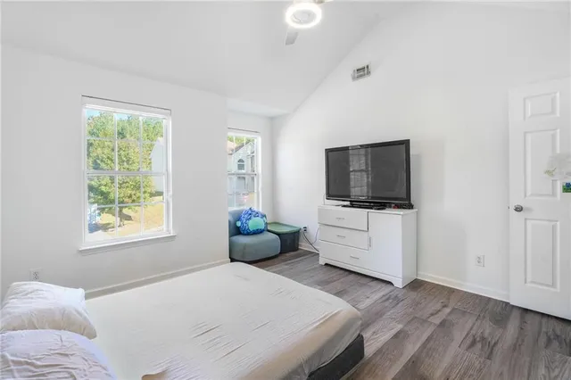 a bedroom with a flat screen tv on a bed and a flat screen tv