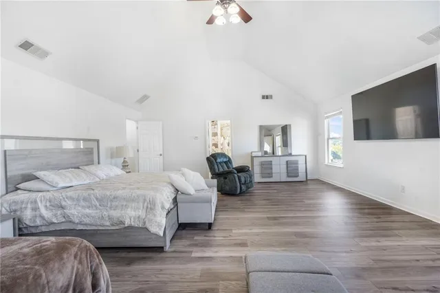 a bedroom with a large bed and a chandelier