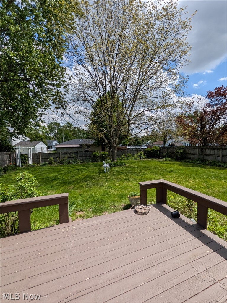 1161 Gulf Road Elyria, OH 44035 - Photo 7 of 34 Expansive backyard featuring a lush lawn, mature trees, and privacy fencing