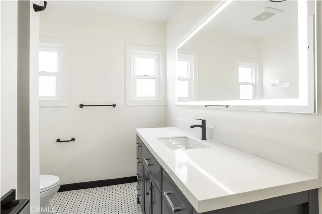 a bathroom with a sink a toilet and window