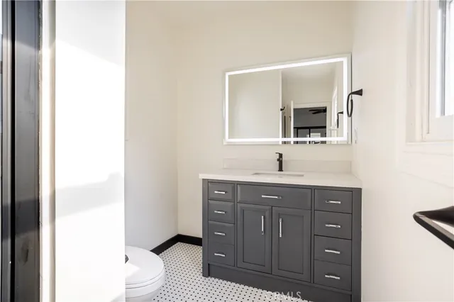 a bathroom with a toilet a sink and mirror
