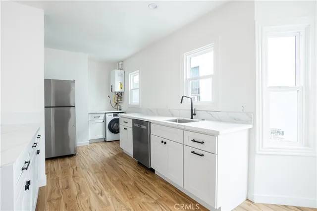 a kitchen with a refrigerator sink and wooden floor