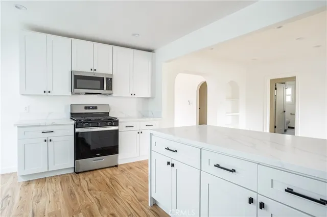 a kitchen with granite countertop a sink cabinets and stainless steel appliances