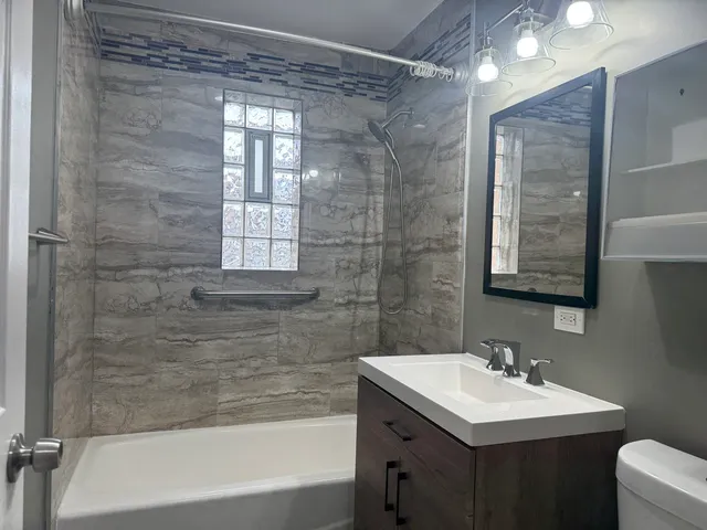 a bathroom with a sink mirror and a bathtub