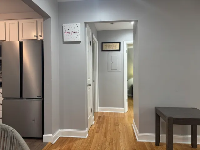 a view of a bedroom with a bed and wooden floor