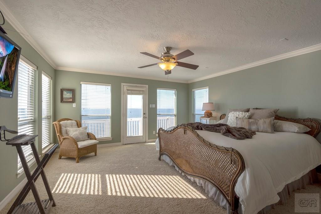 131 Isles End Road Tiki Island, TX 77554 - Photo 18 of 48 a spacious bedroom with a bed and large windows