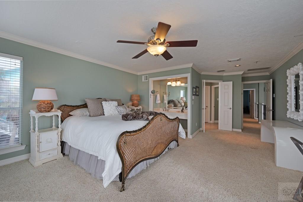 131 Isles End Road Tiki Island, TX 77554 - Photo 19 of 48 a spacious bedroom with a bed and ceiling fan