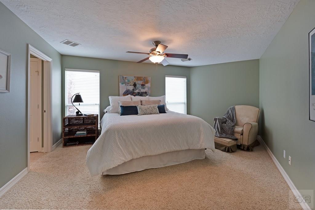 131 Isles End Road Tiki Island, TX 77554 - Photo 27 of 48 a bedroom with a bed and a chandelier