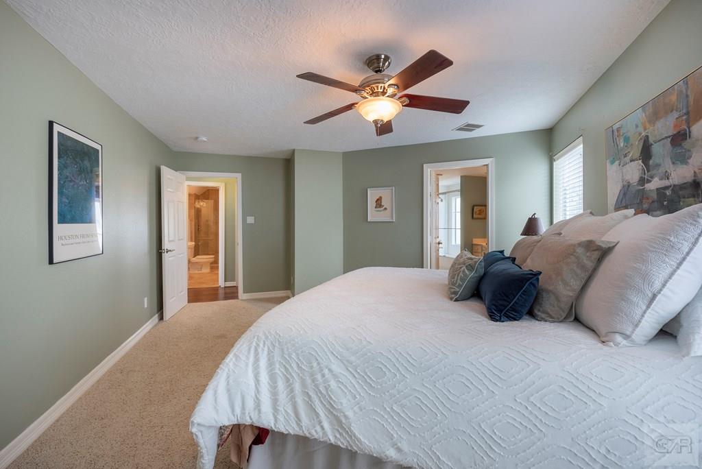 131 Isles End Road Tiki Island, TX 77554 - Photo 28 of 48 a bedroom with a large bed and a chandelier