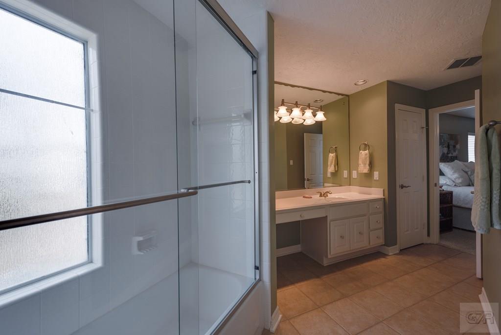 131 Isles End Road Tiki Island, TX 77554 - Photo 30 of 48 a bathroom with a granite countertop sink mirror and a bathtub