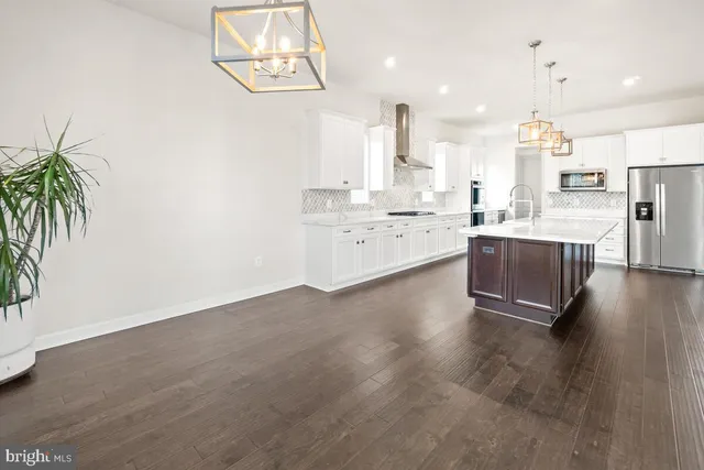 a view of a livingroom with wooden floor and a ceiling fan