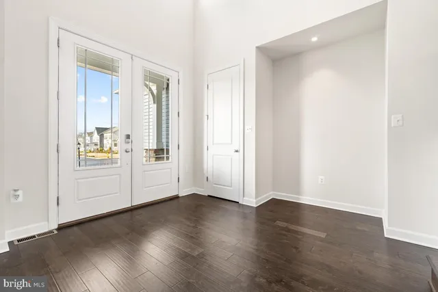 an empty room with wooden floor and white walls