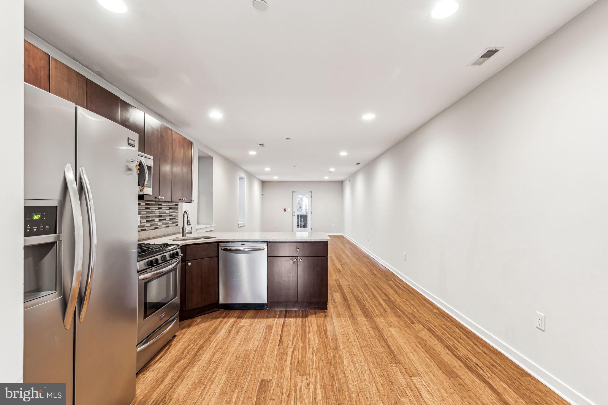 1418 Christian Street, Unit 1 Philadelphia, PA 19146 - Photo 1 of 28 a kitchen with stainless steel appliances granite countertop a refrigerator a sink a stove and oven