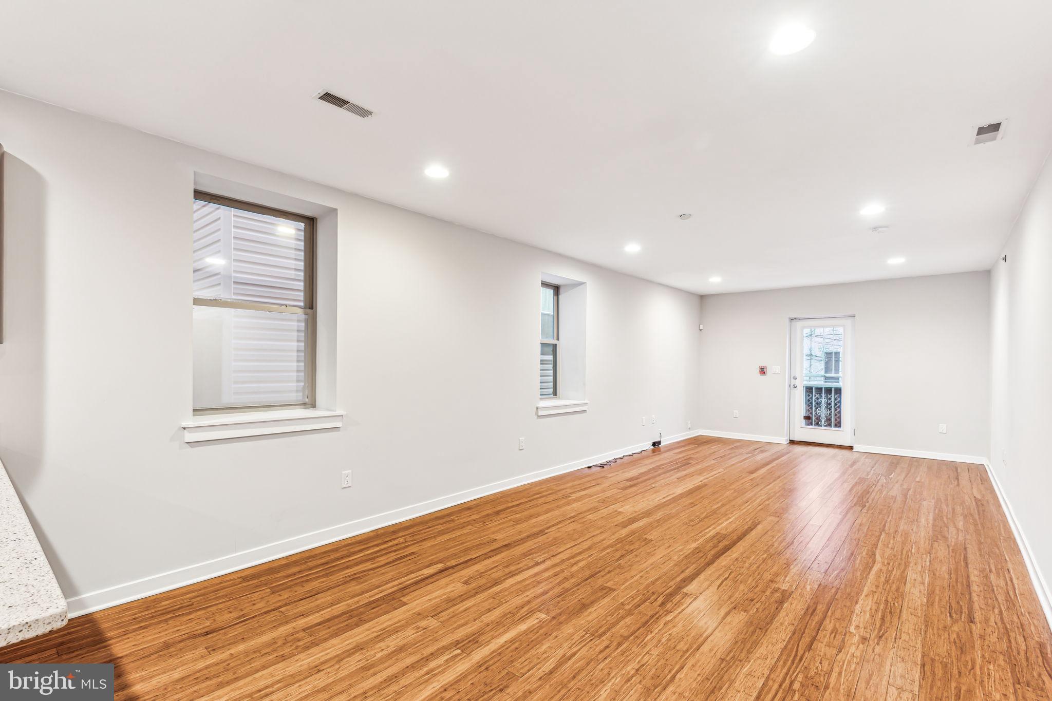 1418 Christian Street, Unit 1 Philadelphia, PA 19146 - Photo 13 of 28 a view of an empty room with wooden floor and a window