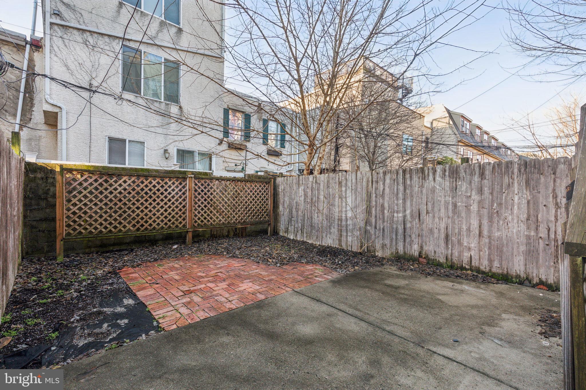 1418 Christian Street, Unit 1 Philadelphia, PA 19146 - Photo 15 of 28 a view of a brick house with a large trees next to a yard