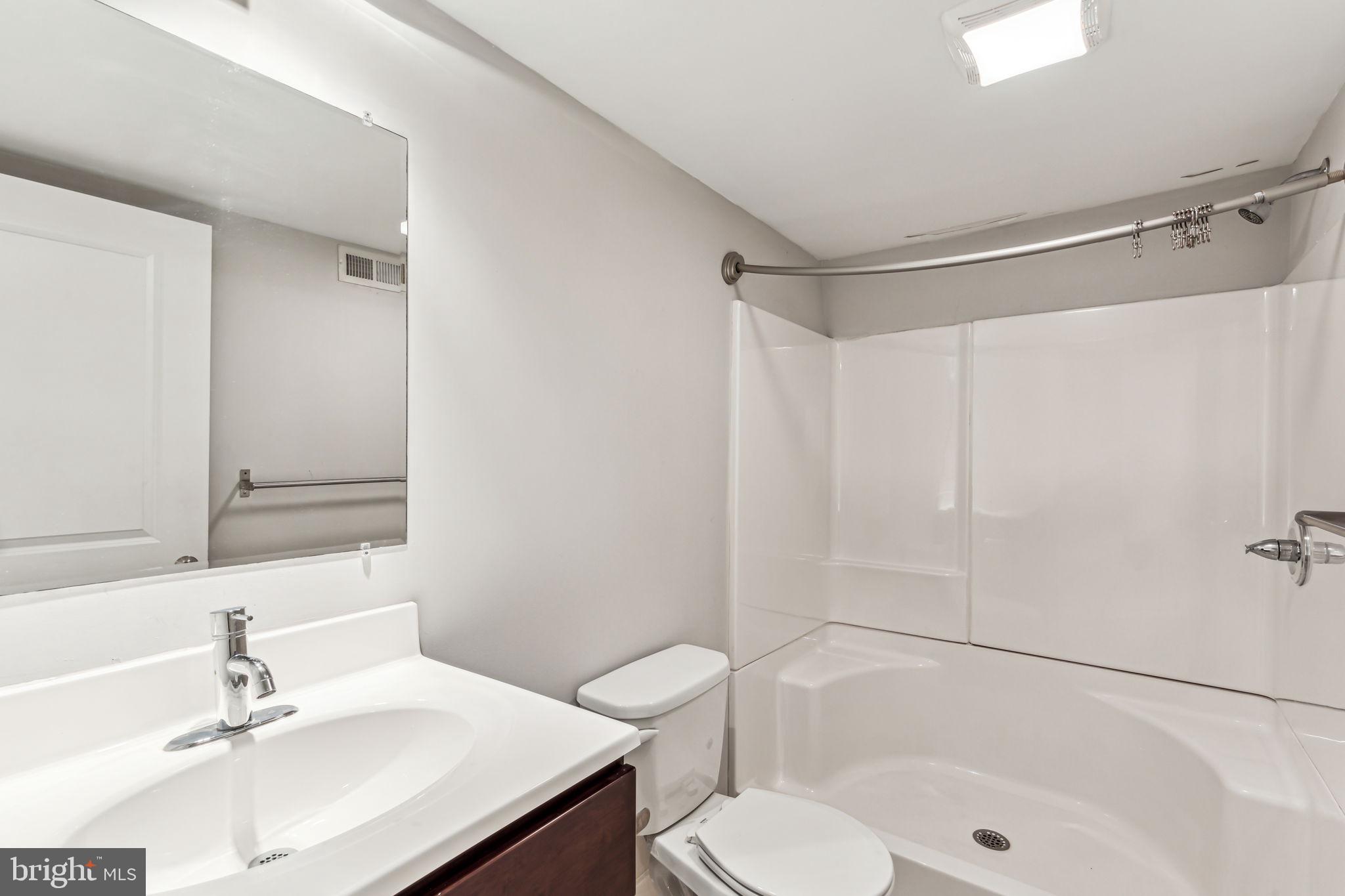1418 Christian Street, Unit 1 Philadelphia, PA 19146 - Photo 21 of 28 a bathroom with a sink toilet a mirror and shower