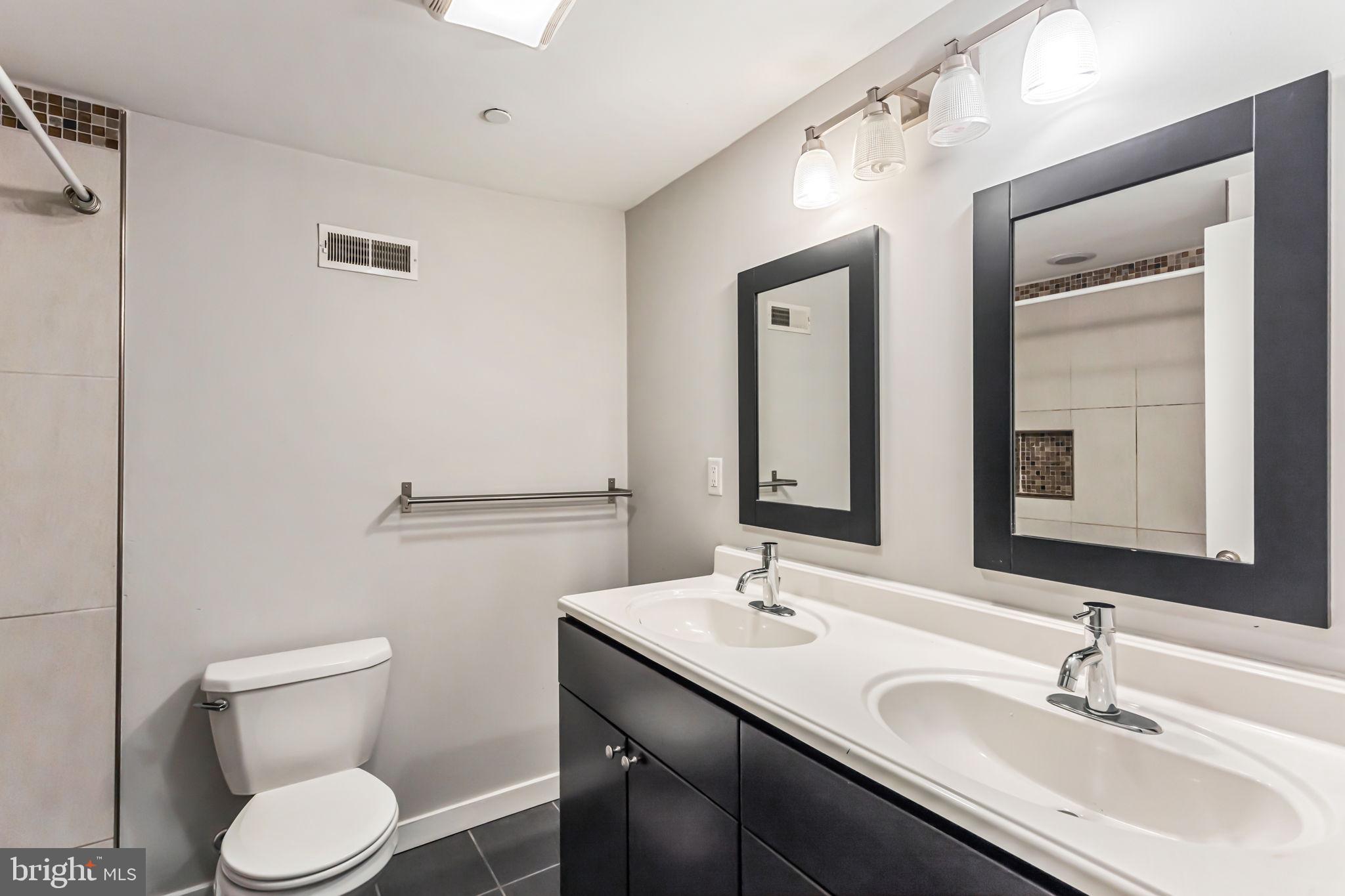 1418 Christian Street, Unit 1 Philadelphia, PA 19146 - Photo 23 of 28 a bathroom with a toilet a sink and mirror