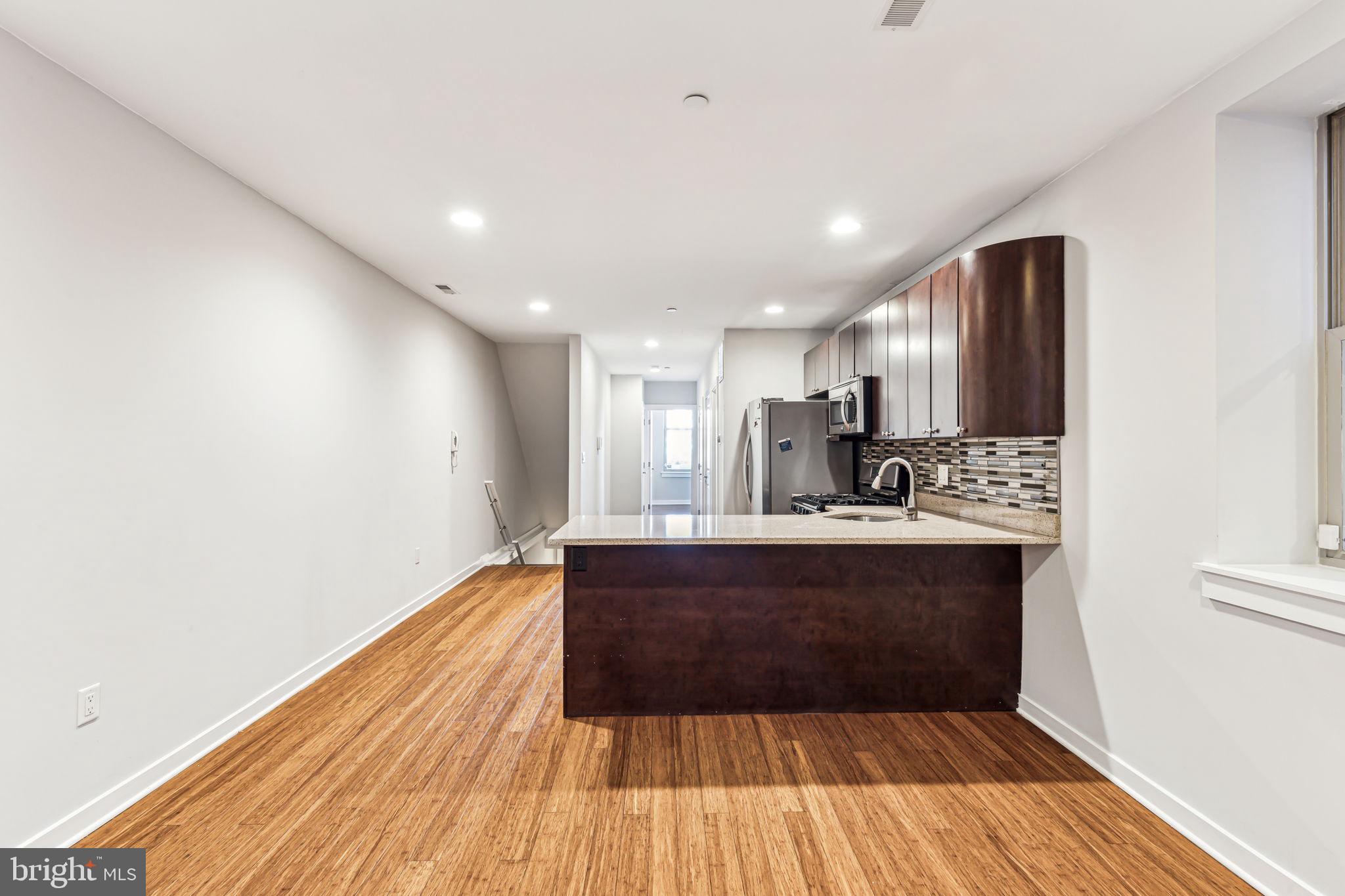 1418 Christian Street, Unit 1 Philadelphia, PA 19146 - Photo 5 of 28 a view of kitchen with cabinets and wooden floor