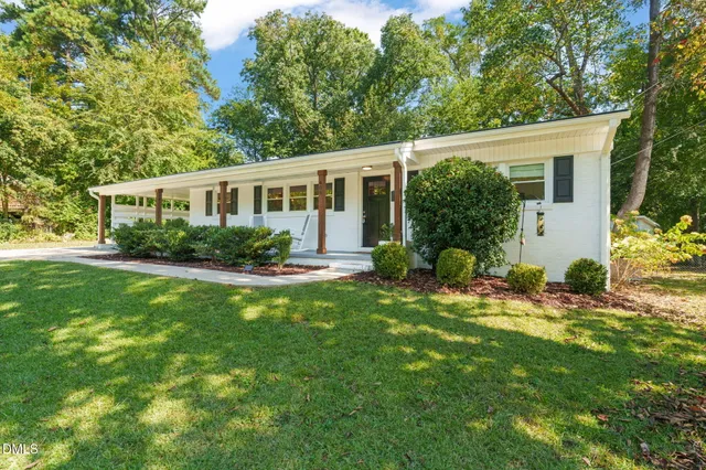 a view of a house with a backyard and a patio