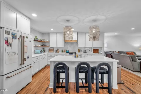 a kitchen with stainless steel appliances a table chairs and a refrigerator