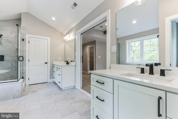 a bathroom with a granite countertop sink mirror and window