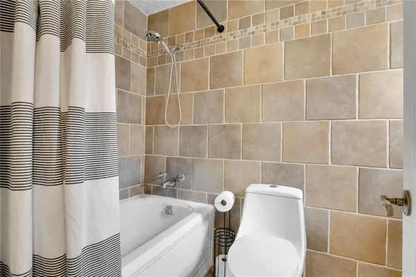 a front view of house with outdoor seating and covered with trees