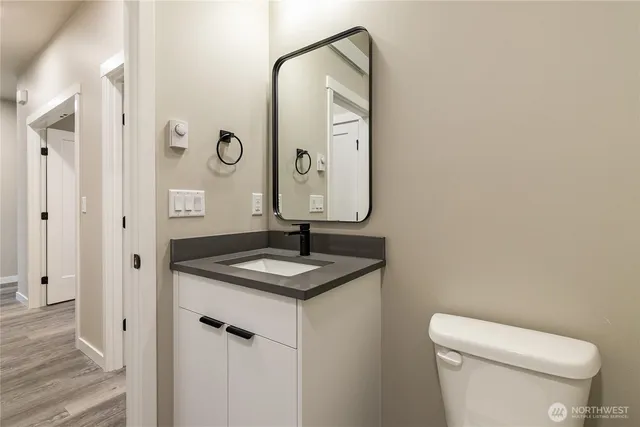 a bathroom with a toilet sink vanity and mirror