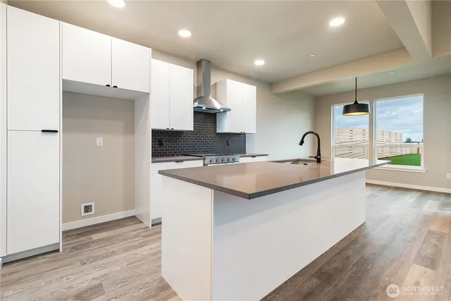 a kitchen with kitchen island a sink and a stove top oven