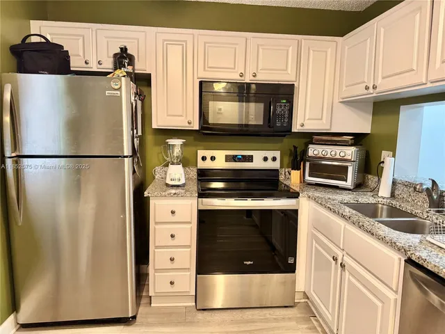 a kitchen with stainless steel appliances a refrigerator stove and microwave
