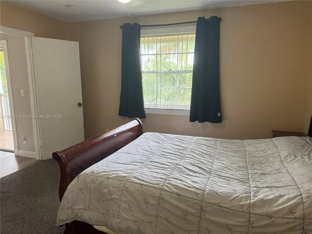 an empty room with wooden floor mirror and windows