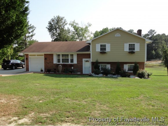 1013 Myra Road Raeford, NC 28376 - Photo 1 of 25 a front view of a house with a garden