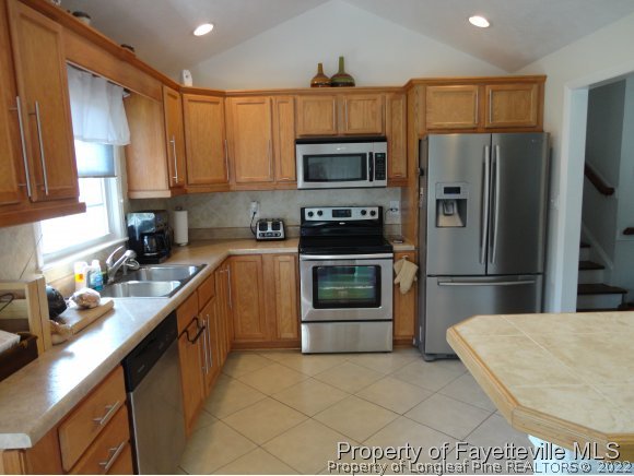 1013 Myra Road Raeford, NC 28376 - Photo 13 of 25 a kitchen with stainless steel appliances a refrigerator sink stove microwave and cabinets